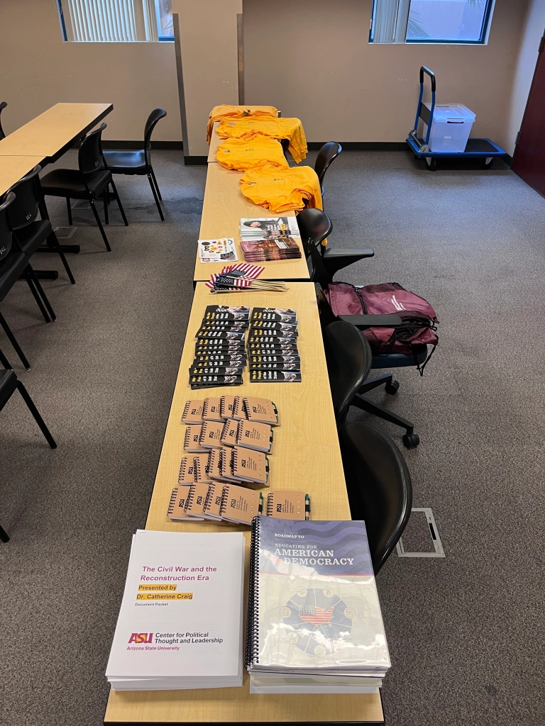 Workshop materials, booklets, shirts, on tables