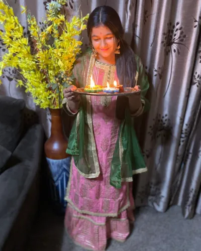 Adya Sharma holding platter of candles next to yellow flowers