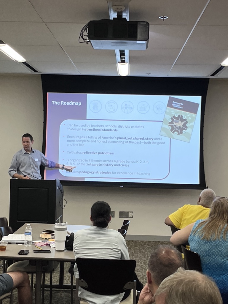 Man presenting in front of screen with slides