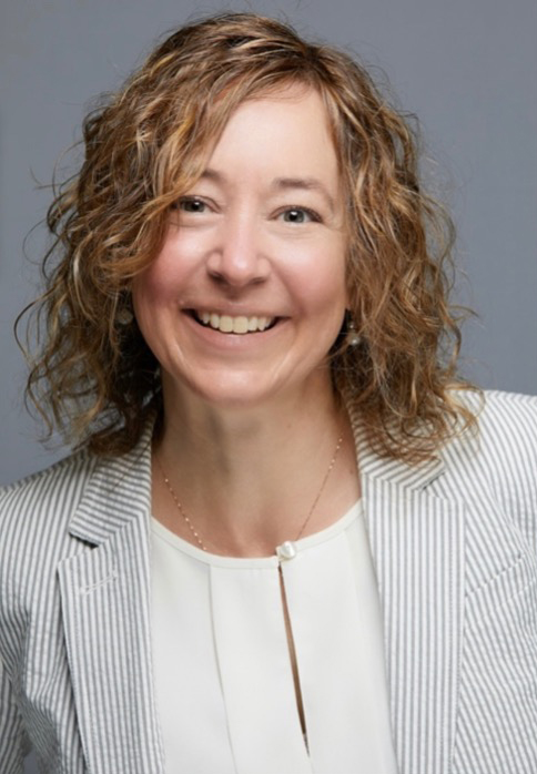 Tammy Morrow smiling, wearing white shirt and striped blazer