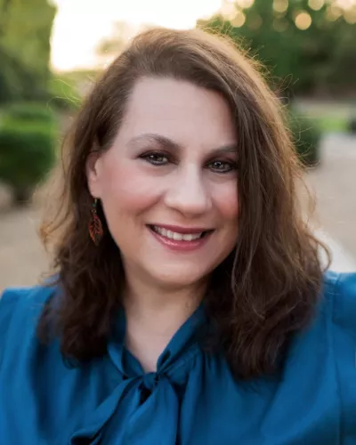 Tammy Waller portrait photo wearing blue shirt with greenery in background