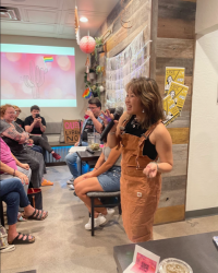 Woman speaking into microphone next to people